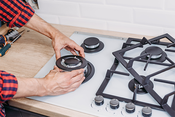 Man-installing-a-gas-hob-in-a-kitchen